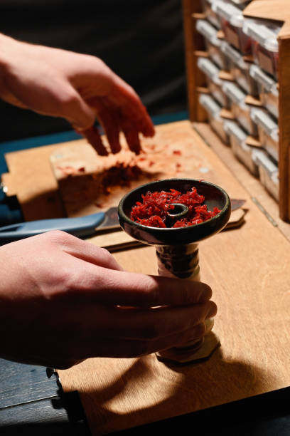 istock bartender preparing tobacco for smoking hookah 1198544642