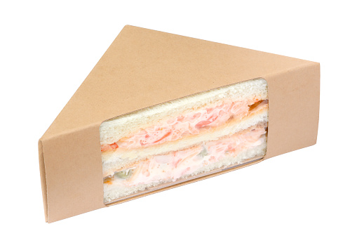 Sandwich with crab stick in brown cardboard triangle packaging isolated on white background