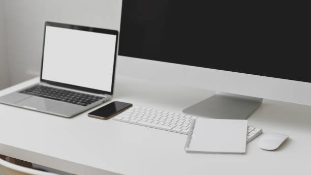 istock Cropped shot of workspace with blank screen laptop, computer, smartphone and notebook on white table 1198552472