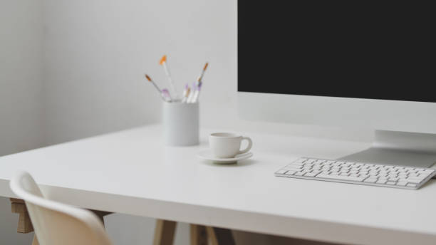 istock Close up view of workspace with computer, painting brush and coffee cup on white table 1198552482