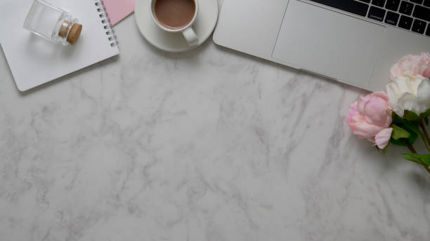 istock Top view of workspace with copy space, laptop, office supplies and tea cup on marble table 1198552493