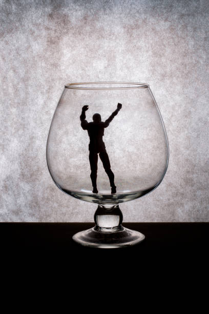istock The silhouette of a human figure inside a glass goblet 1198553980