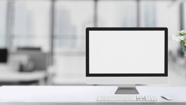 istock Cropped shot of simple workspace  with blank screen computer on white table with blurred office room 1198554091
