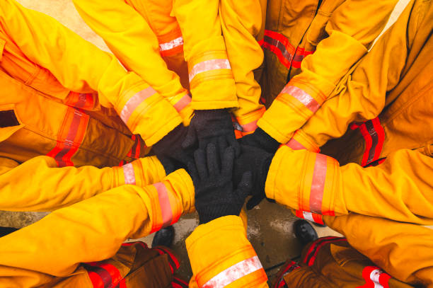 istock Firefighter putting hands up for fire fighting, Cheerful people giving strength motivation. Teamwork concept 1198560664