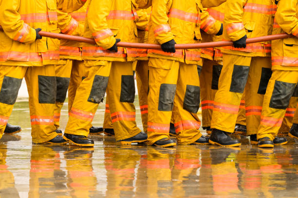 fireman fighting fire flame with water and extinguisher in training workshop, Teamwork and emergency concept