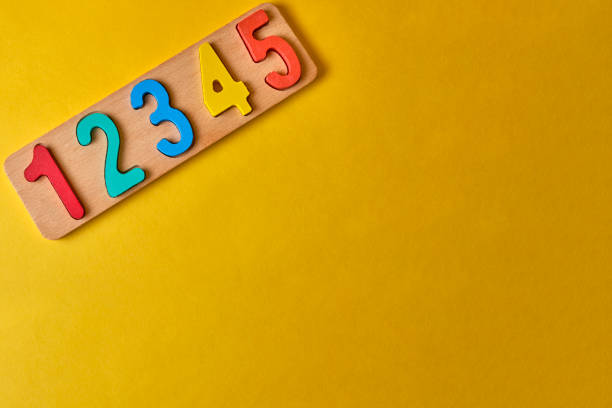 istock wooden colorful digits and plank at yellow background with copyspace 1198561460
