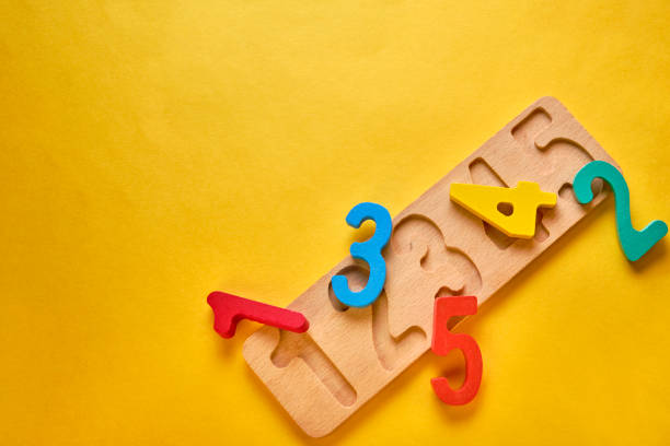istock wooden colorful digits and plank at yellow background with copyspace 1198561515