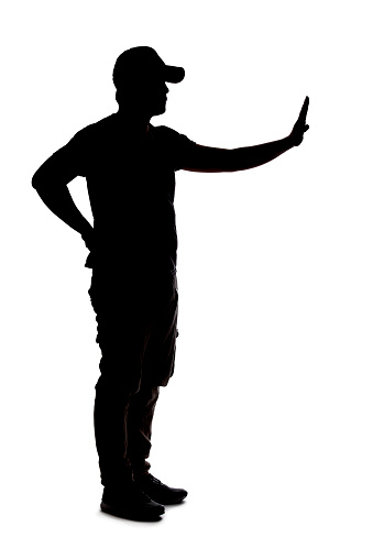 Silhouette of a man wearing casual clothes isolated on a white background. He is blocking defensive or doing stop gesture