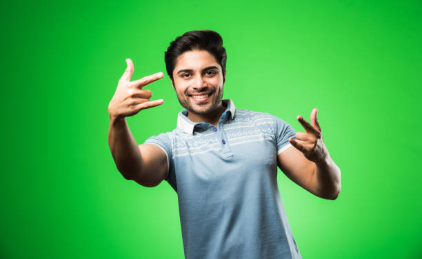 istock Indian handsome man with success gesture, standing isolated over green background 1198564291