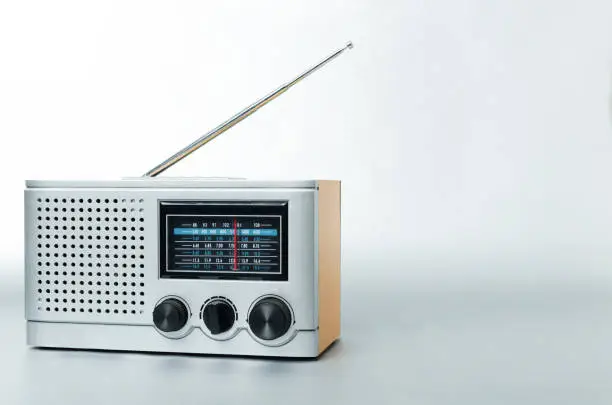 Photo of Old type of radio with fm channels and antenna on the gray background