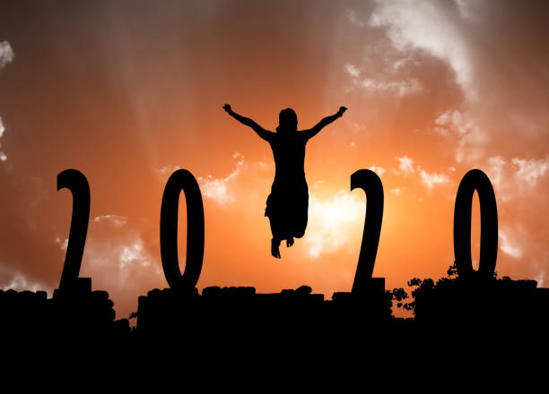 2020, silhouette of a successful woman jumping 2020 on dark wall with silhouette of  a young woman jumping in the air and sunset background. chapora fort stock pictures, royalty-free photos & images