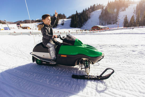 冬の風景の中でスノーモービルを運転する少年 - snowmobiling snow winter mountain ストックフォトと画像