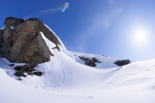 Snowboarder jumping off a cliff.