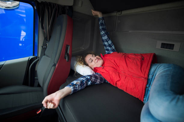 トラック運転手のライフスタイル。長い乗り物の後、彼のキャビンで目を覚ますトラック運転手。ベッドで眠っているドライバーとトラックキャビンのインテリア。 - truck semi truck blue truck driver ストックフォトと画像