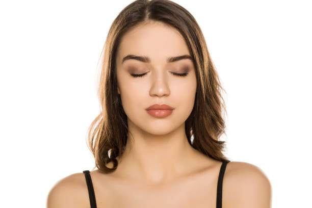 istock Young woman with makeup and closed eyes, posing on white background 1198585536