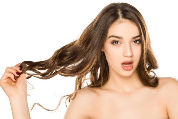 istock Young woman with makeup ad long hair, posing on white background 1198585576