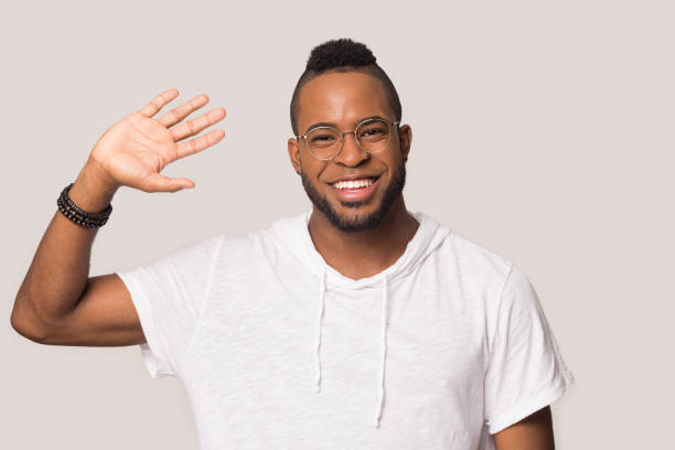 istock Smiling african American man waving to camera greeting 1198585628