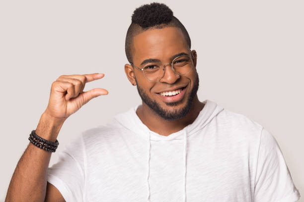 istock Smiling african American man show small amount with hands 1198585635