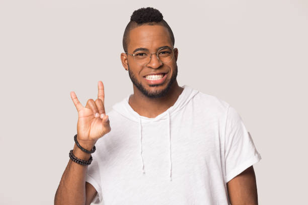 istock Smiling biracial man rocker show rock-n-roll hand gesture 1198585638