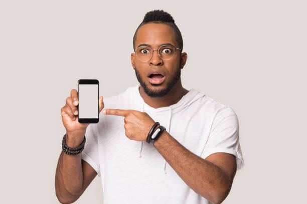 istock Shocked african American man show cellphone screen 1198585646