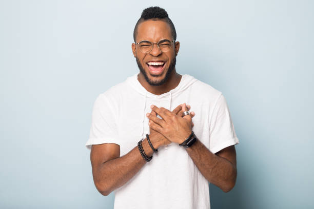 istock Happy african American man keep hands at chest laughing 1198585662