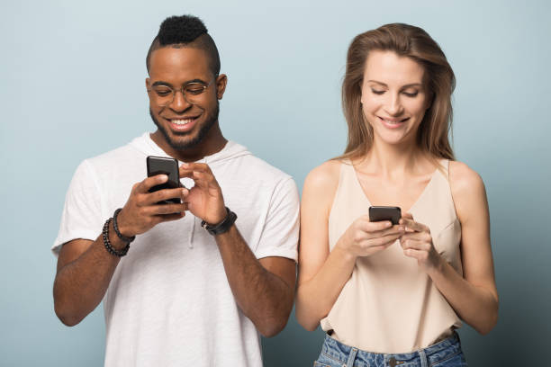 istock Smiling multiracial couple using modern smartphones internet connection 1198585677