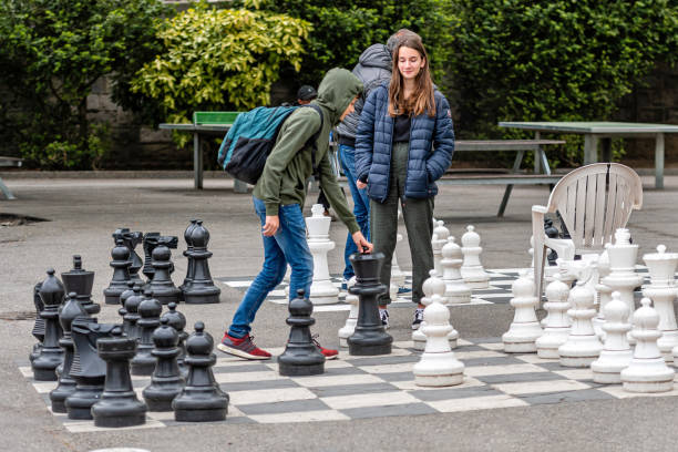 Geneva, Switzerland - April 16, 2019: People playing traditional oversized street chess in Parc des Bastions - image