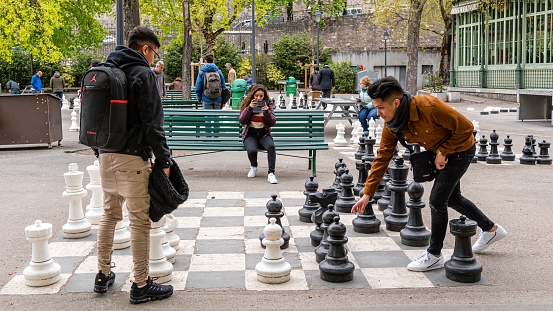Geneva, Switzerland - April 16, 2019: People playing traditional oversized street chess in Parc des Bastions - image