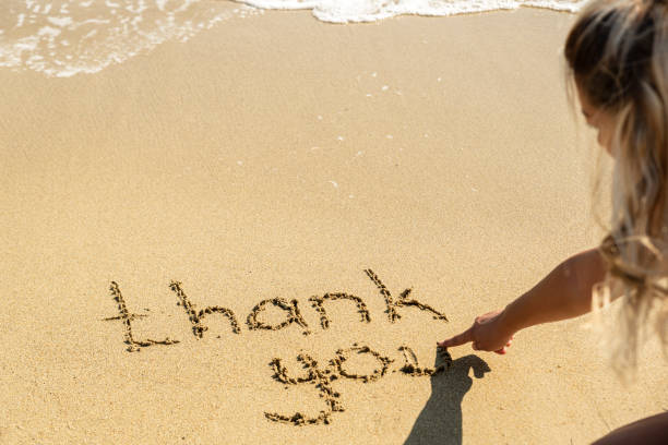 Sand writing thank you washed by ocean waves on a sunny beach in rhodes, greece