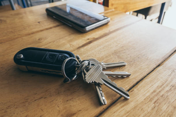 istock car remote keys and Mobile phone on wooden table. 1198590898