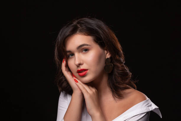 istock Beautiful woman with bright makeup posing isolated over black background. 1198592166