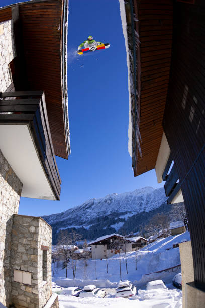 snowboarder jumping from a roof. - ski jumping snowboarding snowboard jumping imagens e fotografias de stock