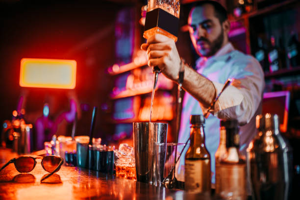 istock Barkeeper pouring a drink in a mixer 1198594316
