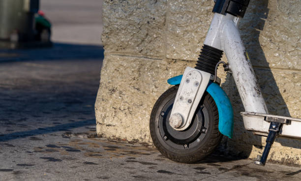 istock Electric hireable scooter standing against wall in urban downtown scene 1198594966