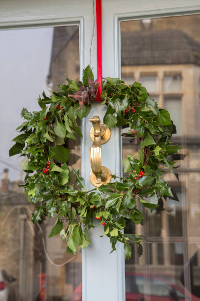 istock Holly Leaf Christmas Wreath on Front Door Window 1198595014