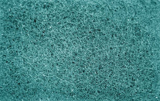 istock Cleaning sponge rubbing surface close up with blur effect in cyan color. 1198595316
