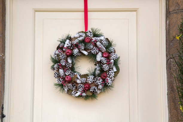 istock Fir Cones, Christmas Wreath on Wooden Front Door 1198595343