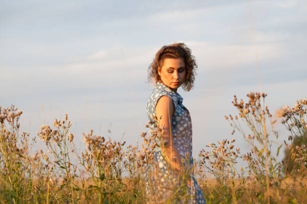 istock woman in summer field at sunset 1198596733