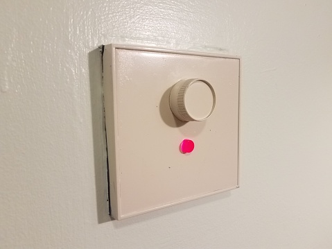 white dimmer switch on wall with red light