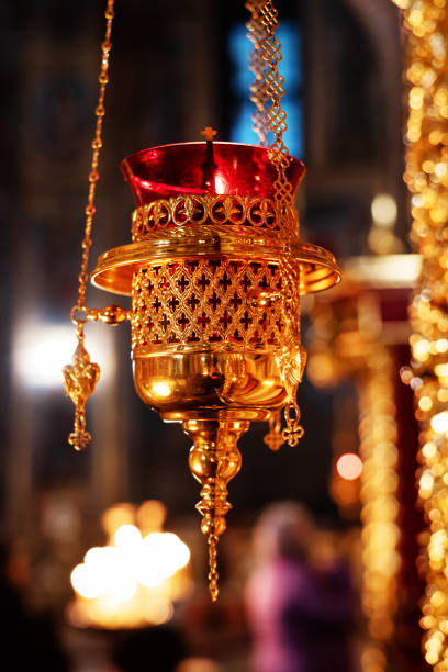 lampe d'icône suspendue de verre rouge transparent dans le support d'or dans l'église orthodoxe. ustensile d'autel d'église doré. closeup - church altar indoors dark photos et images de collection