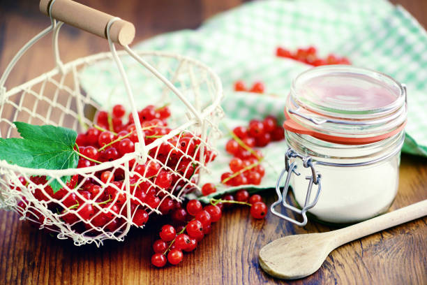 red currant jam making with sugar and fresh fruits. Basket and jar glass aside