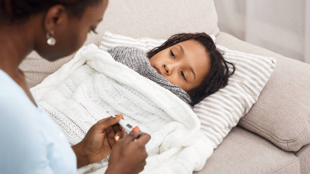 istock Afro mom checking temperature of her ill daughter 1198599982