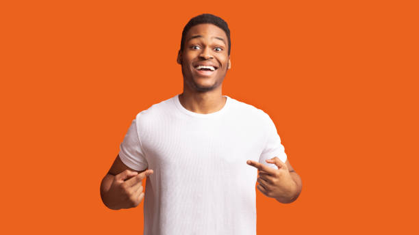 Smiling african guy pointing at his t-shirt