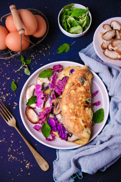 istock Stuffed omelette with mushroom and purple cabbage for breakfast on white plate 1198604230