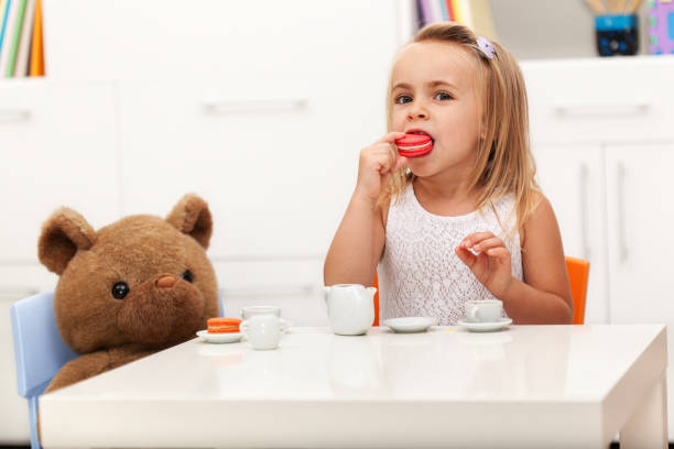 niña que tiene una fiesta de té con su oso de juguete - tea party party tea little girls fotografías e imágenes de stock