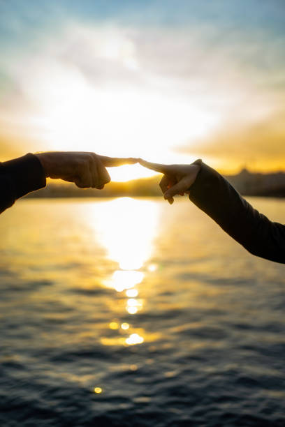 istock Silhouette of human hands on sunset.Trust and help concept 1198604665