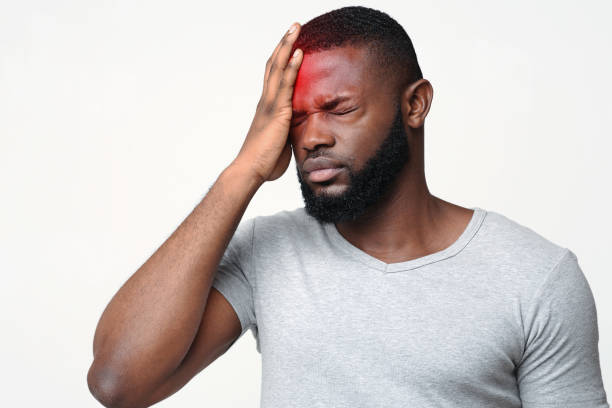 Young man suffering from terrible strong head pain Young man suffering from terrible strong head pain, touching his forehead, photo with red sore zone concussion stock pictures, royalty-free photos & images