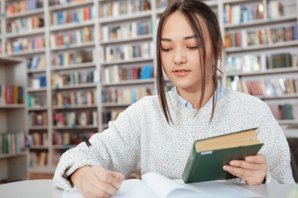 istock Attractive female student studying at the library 1198605907