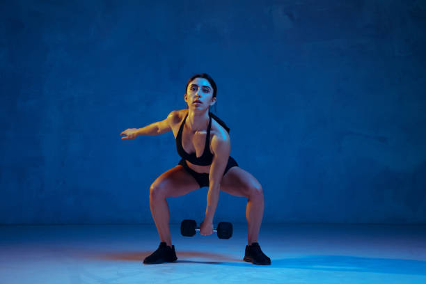 istock Caucasian young female athlete practicing on blue studio background in neon light 1198607212
