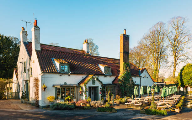 South Dalton, UK - December 30, 2019: View of old and beautiful public house and restaurant surrounded by leafless trees in winter on a bright morning on December 30, 2019 in South Dalton, Yorkshire, UK.